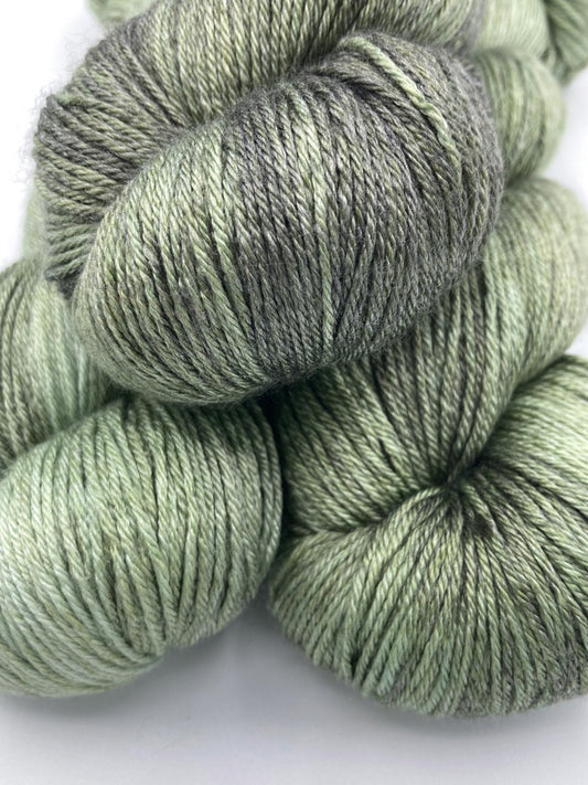 Stack of three twisted hanks of Avocado silk blend yarn by Red Door Fibers (tonal)