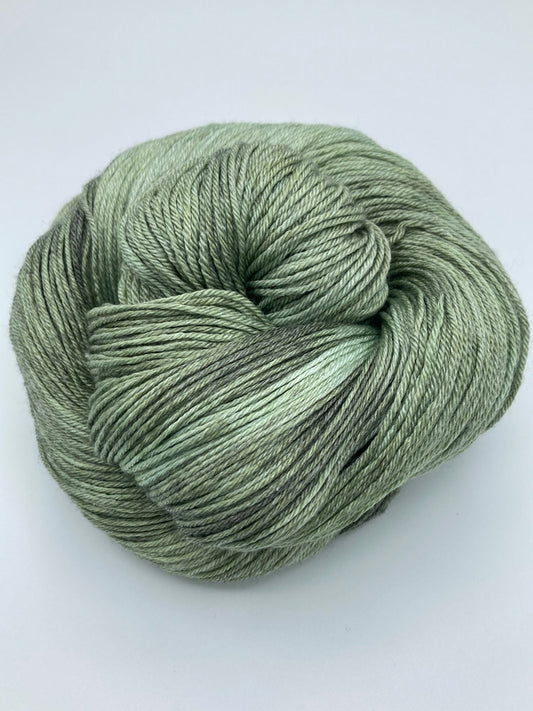 Rolled hank of Avocado silk blend yarn by Red Door Fibers (tonal)