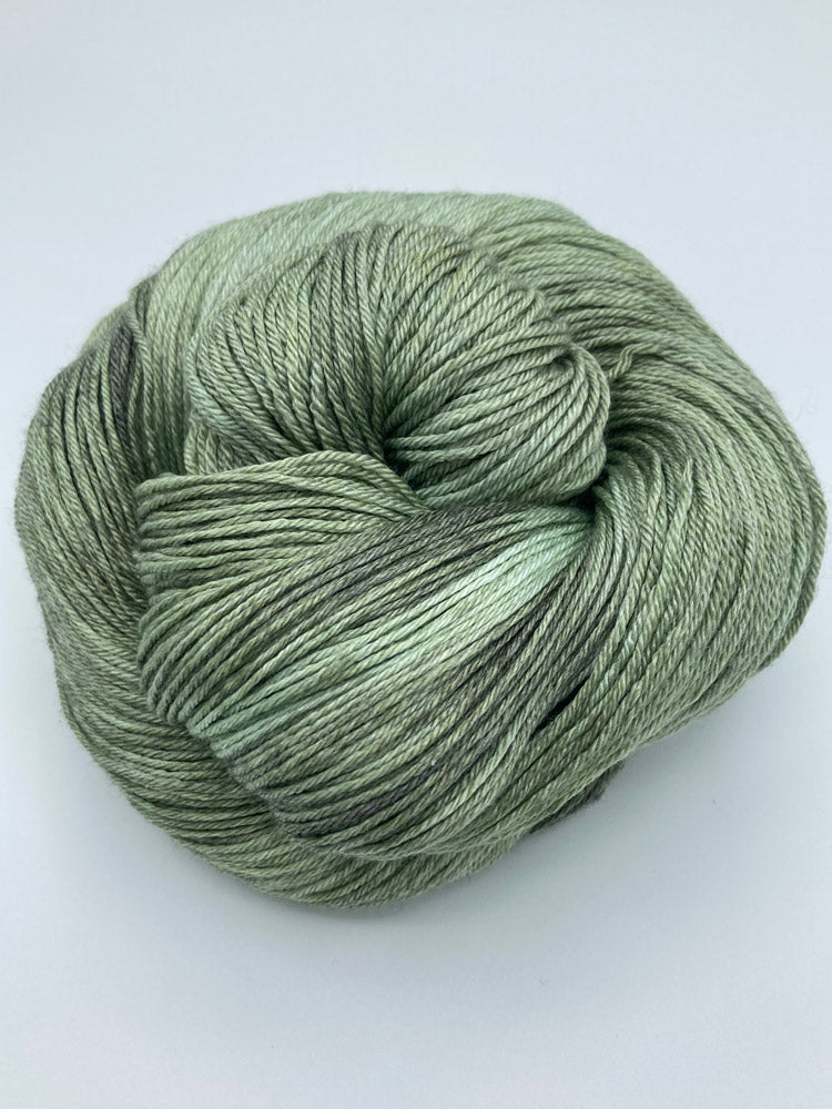 Rolled hank of Avocado silk blend yarn by Red Door Fibers (tonal)