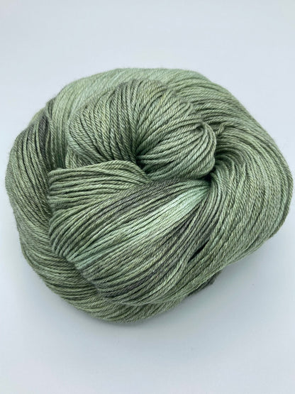 Rolled hank of Avocado silk blend yarn by Red Door Fibers (tonal)