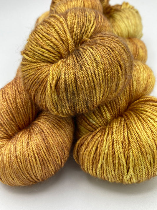 Three twisted hanks of Cowardly Lion silk blend yarn by Red Door Fibers (tonal)
