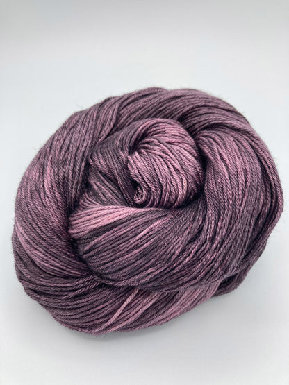Rolled hank of Plum Dandy silk blend yarn by Red Door Fibers (tonal)