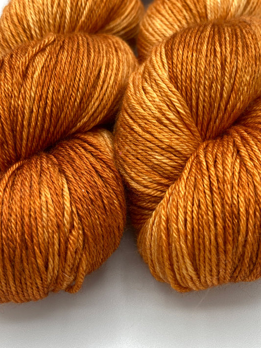 Three twisted hanks of Pumpkin Spice silk blend yarn by Red Door Fibers (tonal)