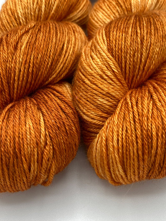 Three twisted hanks of Pumpkin Spice silk blend yarn by Red Door Fibers (tonal)