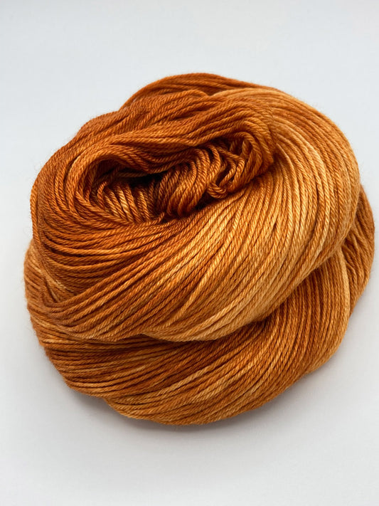 Rolled hank of Pumpkin Spice silk blend yarn by Red Door Fibers (tonal)