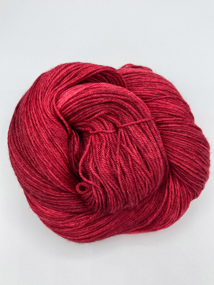 Rolled hank of Ruby Slippers silk blend yarn by Red Door Fibers (tonal)