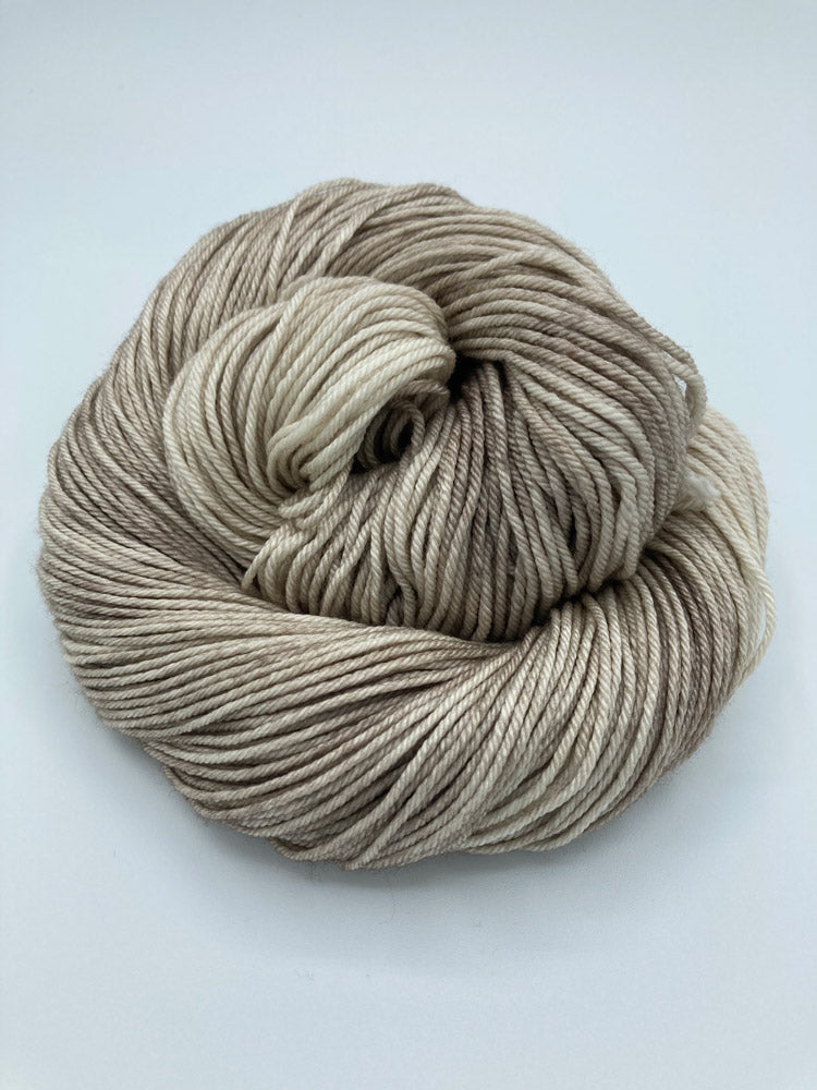 Rolled hank of Sand Dune silk blend yarn by Red Door Fibers (tonal)