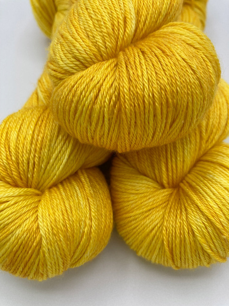 Three twisted hanks of Yellow Brick Road silk blend yarn by Red Door Fibers (tonal)
